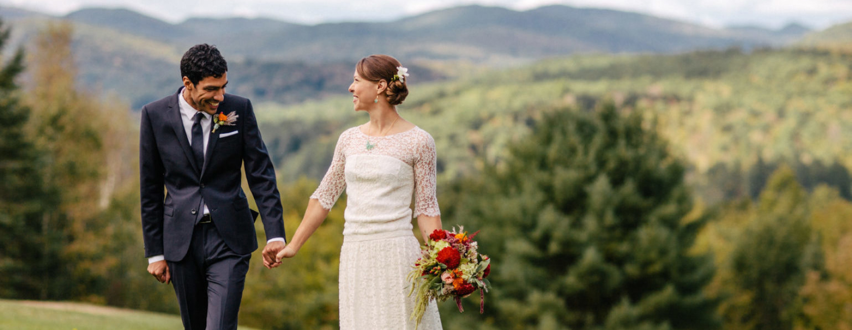 A couple celebrating their wedding holding hands outside.