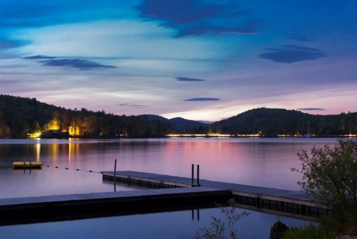 A sunset view of a dock on a lake.