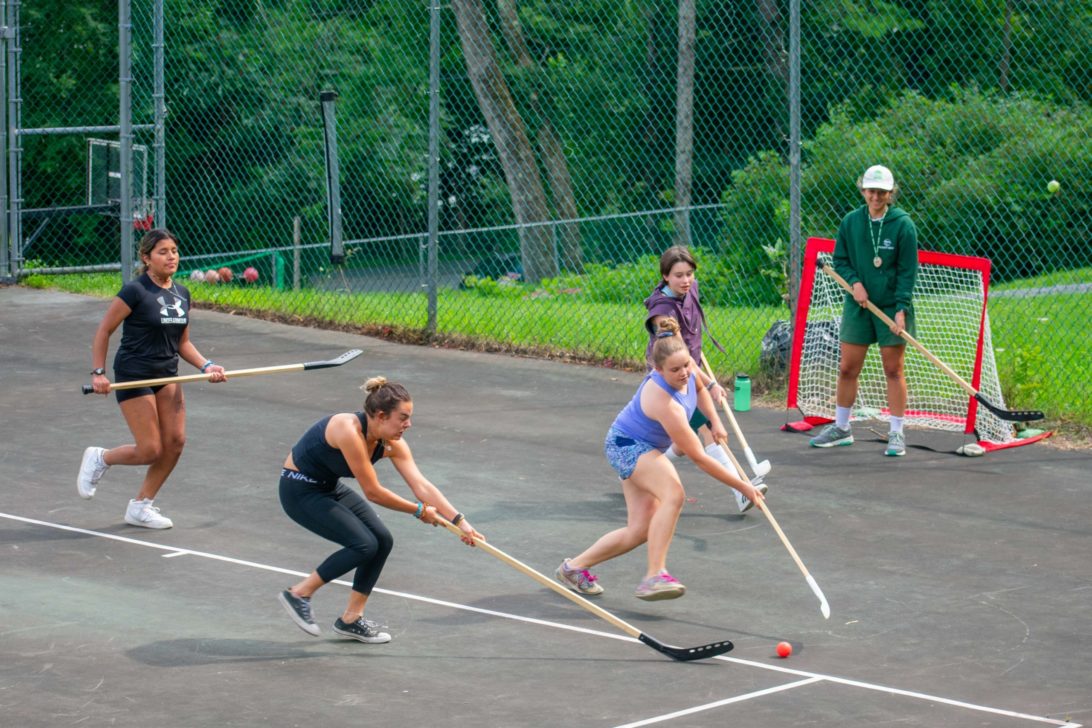 Campers playing street hockey.
