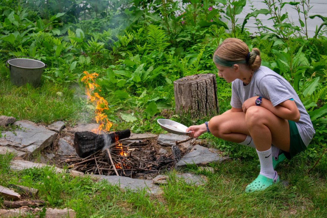 A camper cooking over a campfire.