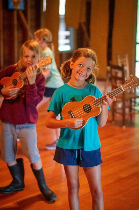 A girl playing a ukulele.