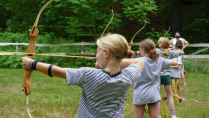 Campers aiming bow and arrows.