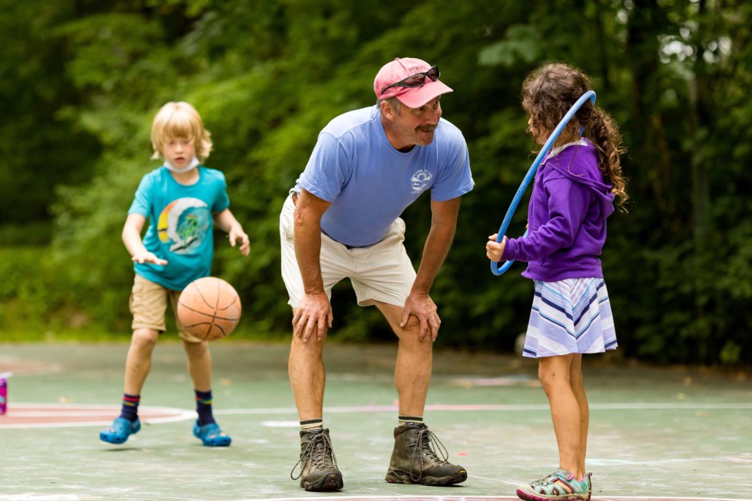 A Horizons staff member leaning down to talk to a camper.