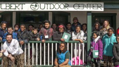 A school group and Hulbert staff gathered on the front porch of The Hulbert Outdoor Center.