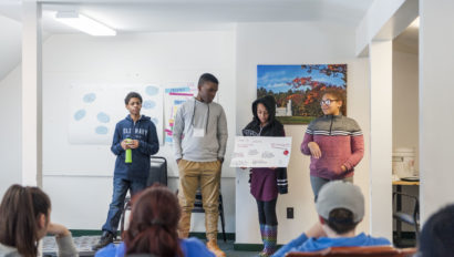 Four students presenting a poster.