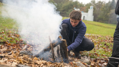 A Hulbert student making a fire.