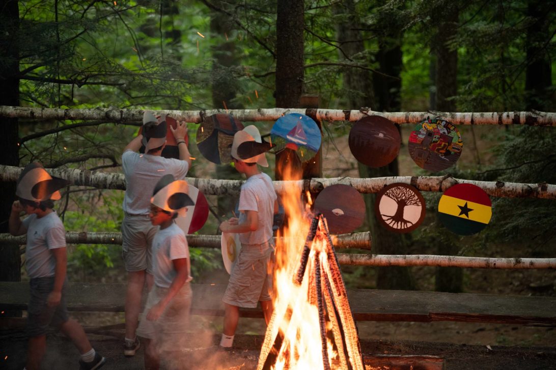 Campers around the bonfire hanging their viking shields.