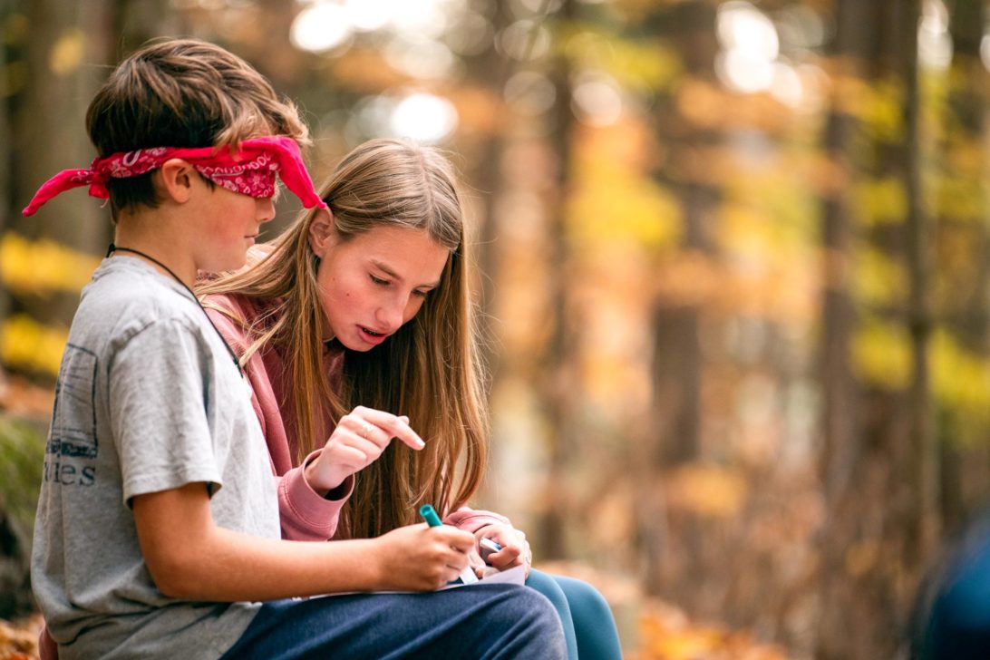 Campers sitting outside doing an activity.
