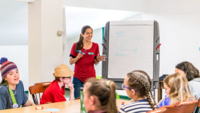 A teacher presenting in front of a group of students.